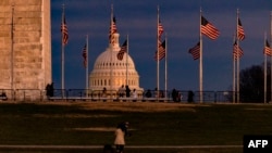 FILE - The US Capitol Building is seen past the Washington Monument as the sun sets on Dec. 26, 2020 in Washington, DC. 
