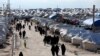 FILE - Women walk through al-Hol displacement camp in Hasaka governorate, Syria, April 1, 2019. 