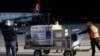 FILE - Airport personal unload the first batch of the AstraZeneca vaccines sent from the Covax facility, at Adem Jashari airport Pristina, Kosovo, March 28, 2021.