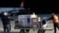 FILE - Airport personal unload the first batch of the AstraZeneca vaccines sent from the Covax facility, at Adem Jashari airport Pristina, Kosovo, March 28, 2021.