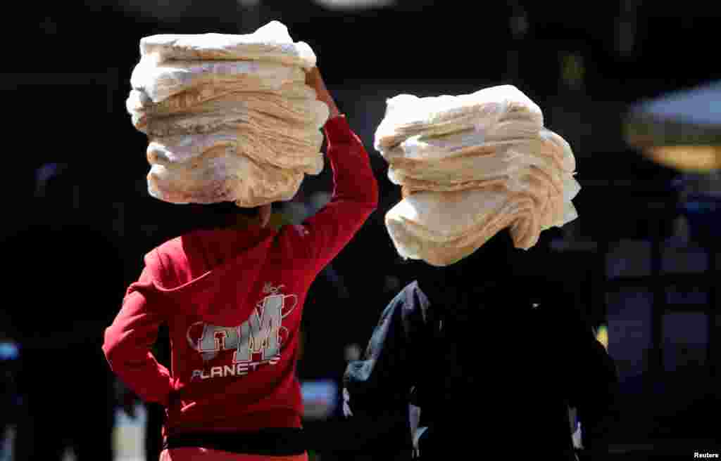 កុមារ​ពីរ​នាក់​ទូល​នំប៉័ង​​ក្នុង​រដ្ឋ​ធានី Damascus​ ប្រទេស​ស៊ីរី។