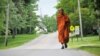 Buddhist monk Sutham Nateetong walks along the road outside Arcola, IN. June 8, 2019.