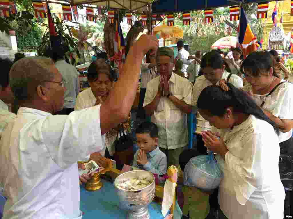 ពុទ្ធ​បរិស័ទ​កំពុង​ឈរ​ទទួល​ពរ​នៅ​ក្នុង​វត្ត​មួយ​កណ្តាល​រាជធានី​ភ្នំពេញ​កាលពី​ព្រឹក​ថ្ងៃសៅរ៍​ ទី​១៦ ខែ កញ្ញា​​ ឆ្នាំ២០១៧។​(កាន់​វិច្ឆិកា/VOA)