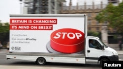 A van with a campaign poster about Brexit is driven around Parliament Square in London, Britain, Sept. 4, 2018. 