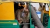 FILE - Aminbanu Memon wearing an oxygen mask sits in an autorickshaw waiting to enter a COVID-19 hospital for treatment, amidst the spread of the coronavirus disease (COVID-19) in Ahmedabad, India, April 28, 2021. 
