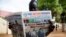 A resident reads a daily newspaper on April 27, 2016 reporting on the arrival and swearing-in of rebel leader Riek Machar in Juba, South Sudan, a day after his return. 