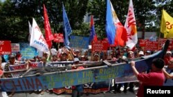 Demonstrators display a part of a fishing boat with anti-China protest signs during a rally by different activist groups over the South China Sea disputes, outside the Chinese Consulate in Makati City, Metro Manila, Philippines, July 12, 2016.
