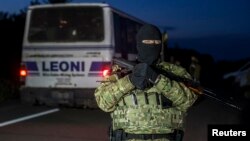 21일 우크라이나 동부 도네츠크에서 포로교환이 이루어진 가운데, 한 정부군 병사가 주변을 지키고 있다.