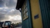 FILE - A farmer drives a tractor past an old customs post at the border between with the Republic of Ireland and Pettigo, Northern Ireland, Dec. 23, 2019.