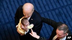 Predsednik Bajden drži Margo Mojhihen, bebu Rebeke Mojnihen, poslanice irske Laburističke partije, pre obraćanja članovima irskog parlamenta u Dablinu, 13. aprila 2023. Foto: Kenny Holston/The New York Times via AP)