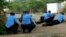 FILE - Kenyan police take cover outside Garissa University College during an attack in Garissa, Kenya, April 2, 2015. Dulyladeyn, the al-Shabab terrorist sought for his role in planning the attack, was killed in an assault this month. 