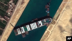 FILE - This satellite image from Maxar Technologies shows the cargo ship MV Ever Given stuck in the Suez Canal near Suez, Egypt, March 27, 2021.