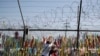 Visitors hang a ribbon on a wire fence decorated with other ribbons at the Imjingak Pavilion in Paju, South Korea, June 9, 2020. North Korea said this week it will cut off all communication channels with South Korea.
