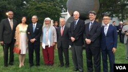 宾客在双橡园与台湾钢雕艺术家康木祥(左4，白发长须)作品合影，2018年9月20日。左起尼加拉瓜驻美大使坎贝尔、台湾驻美代表高硕泰夫妇、康木祥、巴拉圭驻美大使罗哈斯、美国在台协会执行理事罗瑞智、国际艺术与艺术家协会会长佛许戈特、台北101大楼营运长刘家豪(美国之音钟辰芳拍摄) 