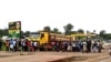 Crowd gathers near checkpoint, which controls the movement of people in and out of Ebola-hit regions, at the entrance to Bomi county in northwestern Liberia, Aug. 11, 2014.