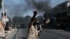 Police clear burning tire road blocks set by protesters upset with growing violence in the Lalue neighborhood of Port-au-Prince, Haiti, July 14, 2021.