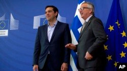 FILE - European Commission President Jean-Claude Juncker, right, speaks with Greek Prime Minister Alexis Tsipras as they arrive for a meeting at EU headquarters in Brussels, Belgium, June 3, 2015.