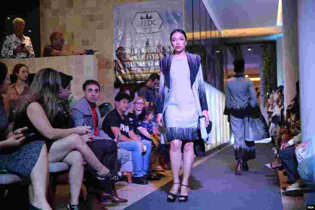 ក្រុម​អ្នក​បង្ហាញ​ម៉ូត កំពុង​ដើរ​បង្ហាញ​ដោយ​ស្លៀក​សម្លៀកបំពាក់​ច្នៃ​ដោយ​យុវតី​ចំនួន​១២​រូប ក្នុង​កម្មវិធី​ការបង្ហាញម៉ូត Fashion Function លើកទីបី នៅ​ល្ងាច​ថ្ងៃ​ទី​១០ ខែសីហា ឆ្នាំ​២០១៩។ (កាន់ វិច្ឆិកា/VOA)
