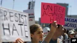 一位女性在旧金山的集会上举着标牌。（2017年8月25日）