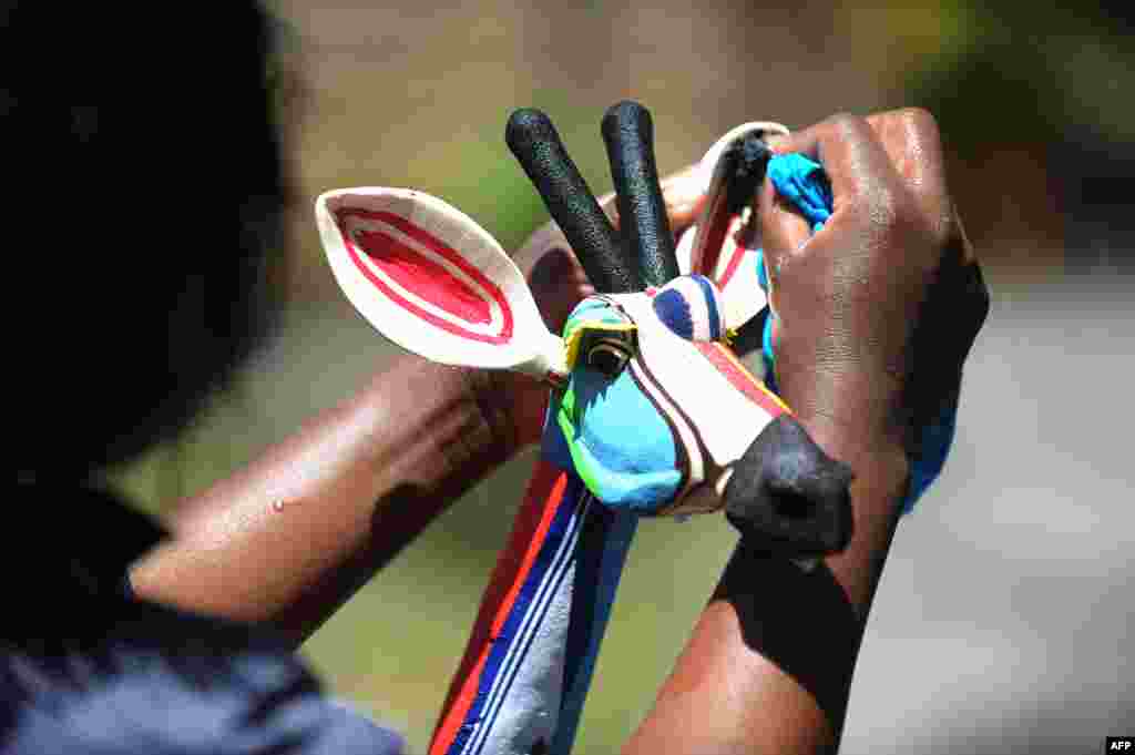 Seorang perempuan menyelesaikan mainan binatang yang dibuat dari potongan sandal jepit bekas di perusahaan daur ulang &#39;Ocean Sole&#39; di Nairobi, Kenya.
