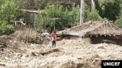 북한 함경북도 무산군 학산리에서 홍수와 산사태로 파괴된 마을에 한 아이가 서있다. 유니세프가 지난해 10월 발표한 북한 수해 실태 보도자료에 실린 사진. (자료사진)