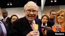 资料照 - 伯克希尔哈撒韦公司（Berkshire Hathaway）董事会主席兼总裁沃伦·巴菲特（Warren Buffett）在他创建的公司的年度会议上津津有味地享用着知名冰激凌甜品“冰雪皇后”。照片摄于2017年5月6日，内布拉斯加州的奥马哈市（Omaha, Nebraska）。