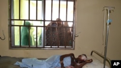 Des femmes tentent d'apercevoir une victime d'un attentat-sucide dans un hôpital de Maiduguri, au Nigeria vendredi 16 octobre 2015; (AP Photo)