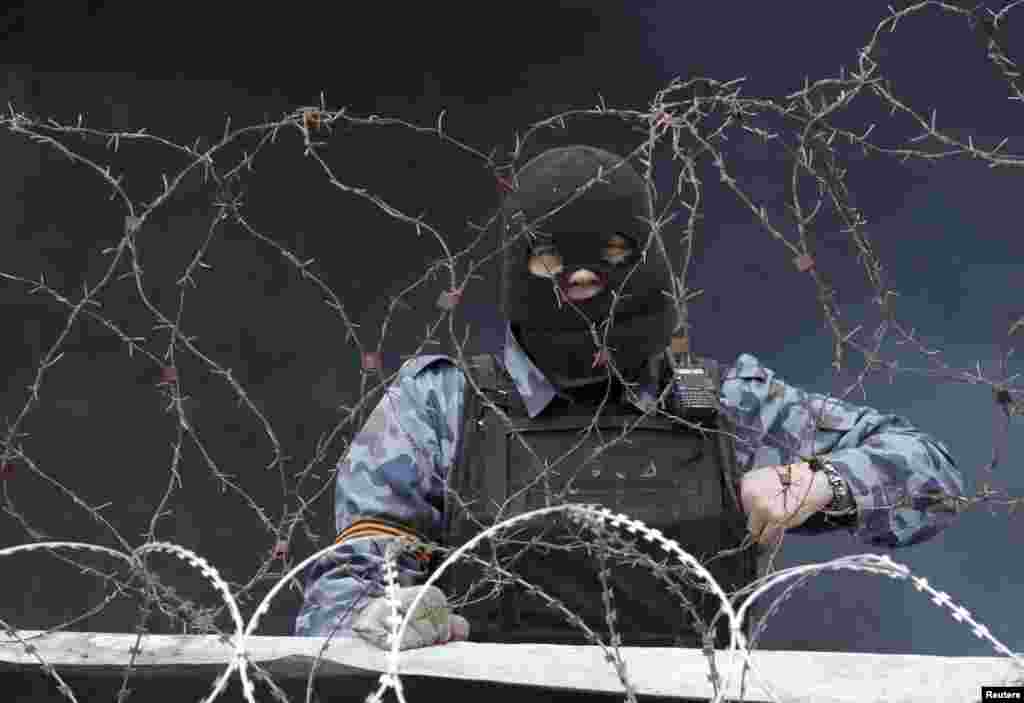 A pro-Russia protester stands at a barricade outside a regional government building in Donetsk, Ukraine.