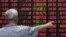 An investor looks at information displayed on an electronic screen at a brokerage house in Shanghai, China, June 30, 2015. 