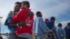 Kybumba Fran, 25, from Cameroon, cries with the head of the mission of Proactive Open Arms NGO Riccardo Gatti, from Italy, as he leaves the Golfo Azzurro rescue vessel after arriving at the port of Pozzallo, south of Sicily, Italy, with more than 220 migr