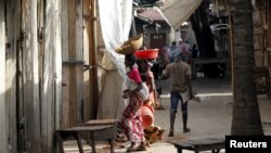 ARCHIVES - Un femme marche à travers un marché déserté après à la suite des manifestations contre la candidature de Pierre Nkurunziza pour un troisième mandat à Bujumbura, le 29 avril 2015. 