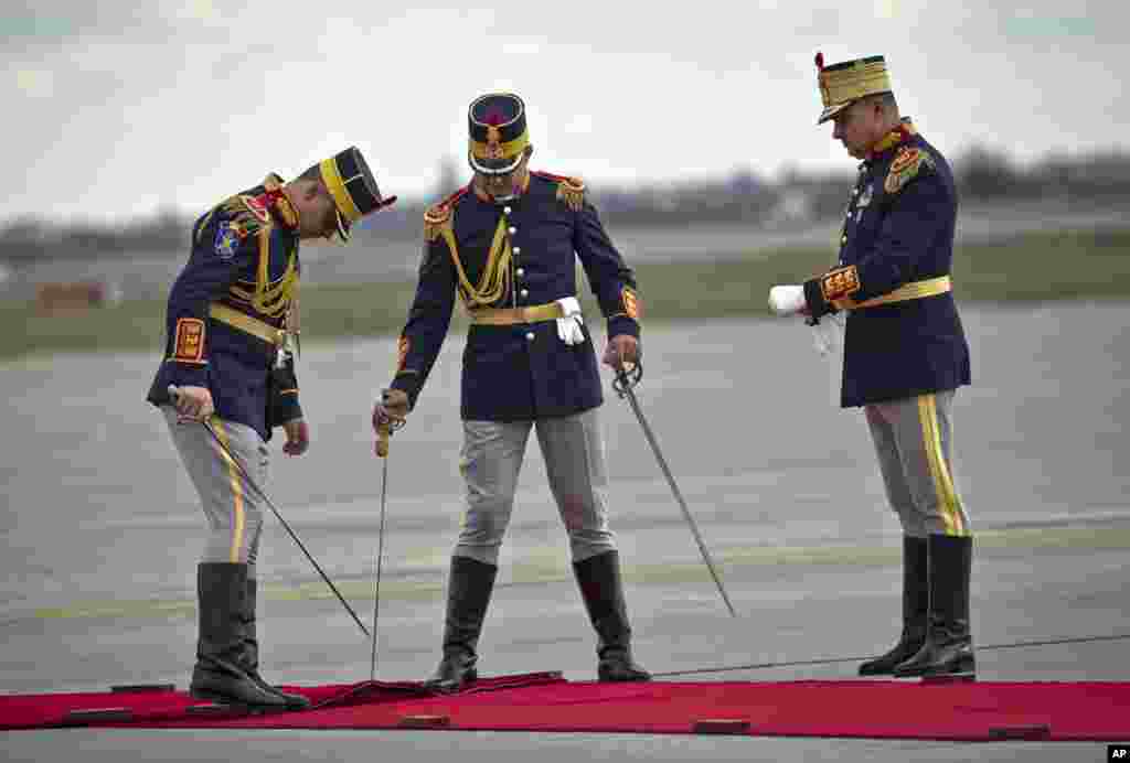 Pasukan kehormatan mengatur karpet merah menjelang kedatangan PM China Li Keqiang di bandara Henri Coanda, di pinggiran Bucharest, Romania.