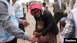 Kijana aliyekimbia vita huko Mosul, akipatiwa chanjo ya suruwa kutoka kwa mfanyakazi wa afya anayesaidiwa na shirka la UNICEF katika mji wa Hamdaniyah, Iraqi Oct. 24, 2016.