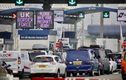 People queue in line to check-in for the channel ferry in Calais, France, Aug.14, 2020.
