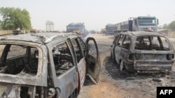 FILE - Burmt cars are seen after a deadly attack by suspected members of the Islamic State West Africa Province (ISWAP) in Auno, Nigeria, Feb. 9, 2020. 