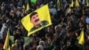 A Syrian Kurdish woman waves a flag bearing a picture of the founder of the Kurdistan Workers' Party Abdullah Ocalan, as people gather in the Kurdish-majority city of Qamishli in northeastern Syria to listen to a message from the jailed leader, Feb. 27, 2025. 