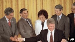 1993年5月克林顿签署李硕（左）等人推动通过的亚裔美国人传统文化纪念法案（美联社）