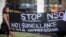 FILE - A protester holds a banner during a protest attended by about a dozen people outside the offices of the Israeli cyber firm NSO Group in Herzliya near Tel Aviv, Israel, July 25, 2021.