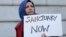 Moina Shaiq holds a sign at a rally outside of City Hall in San Francisco, Wednesday, Jan. 25, 2017.