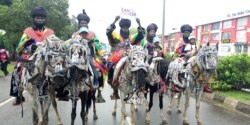 Horsemen from Northern Nigeria hold "cancel cancer" signs during a cancer awareness walk in Abuja, Nigeria, Oct. 26, 2019. (Timothy Obiezu/VOA)