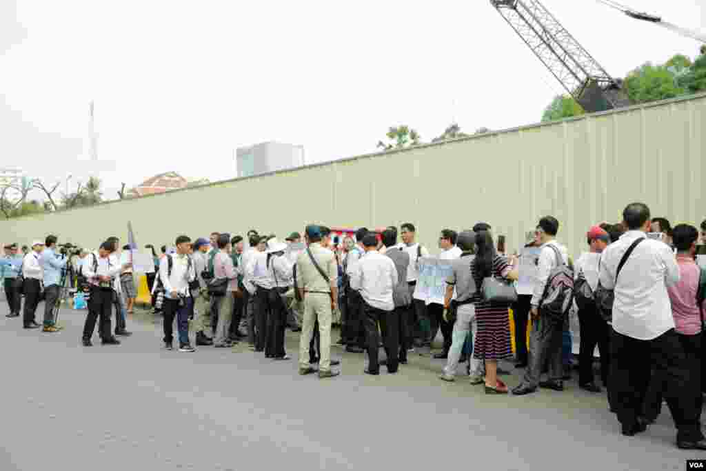 សន្តិសុខ​ដែល​ត្រូវ​បាន​ស្ថានទូត​សហរដ្ឋ​អាមេរិក​បញ្ឈប់​កាល​ពី​ប៉ុន្មាន​ខែ​មុន​​​និង​គ្រួសារ​របស់ពួកគេ​បាន​មក​ធ្វើ​បាតុកម្ម​តវ៉ា​រក​យុត្តិធម៌​ដោយ​អហិង្សា​នៅ​ខាង​មុខ​ស្ថានទូត​អាមេរិករាជធានី​ភ្នំពេញ​ ​កាល​ពីព្រឹក​ថ្ងៃទី​១៩ មិថុនា ឆ្នាំ ២០១៨។(ទុំ ម្លិះ/VOA)