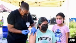 一名14岁的女孩在加州洛杉矶由洛杉矶郡公共卫生局经管、由“母亲在行动”主办的一处移动疫苗接种站接种新冠疫苗。(2021年7月16日) 