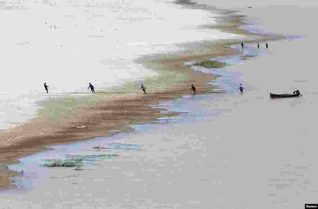 Para nelayan menarik jala yang ditebar di sungai Indus, Hyderabad, Pakistan.