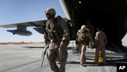 FILE - U.S. Marines disembark from a C-130 transport plane.
