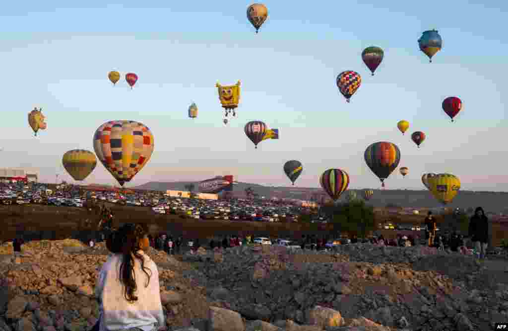 Seorang anak perempuan menikmati festival balon udara di Cajititlan, Jalisco, Meksiko.