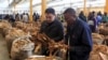 FILE - Buyers check the quality of tobacco during the last day of the selling season at Tobacco Sales Floor, July 15, 2015. The Cameroon government has asked farmers not to plant for the coming growing season until the government can assure them there will be sufficient rainfall.