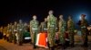 Military pallbearers stand to attention next to the coffins of four Kenyan soldiers who were killed in Somalia, at a ceremony to receive their bodies which were airlifted to Wilson Airport in Nairobi, Kenya Monday, Jan. 18, 2016.