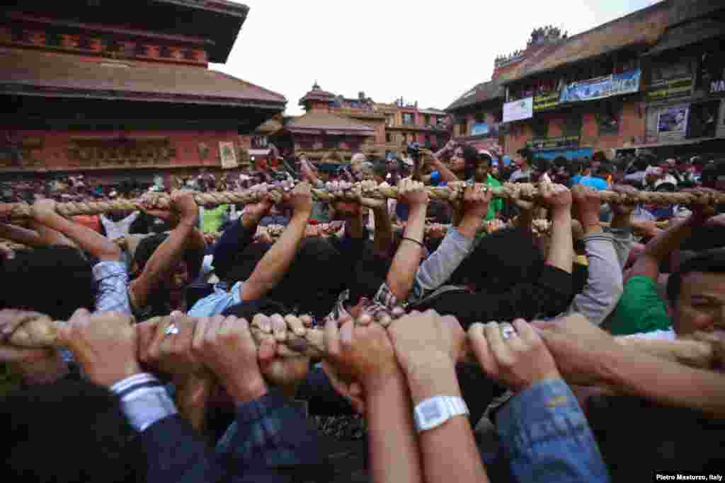 Umat Hindu menarik tali yang diikat pada kereta Dewa Hindu &#39;Bhairab&#39;, melalui pusat kota Bhaktapur dekat Kathmandu, Nepal, selama berlangsungnya festival keagamaan Bisket.