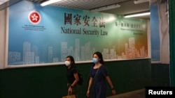 行人走过香港政府在街头张贴的港版国安法宣传标语。（2020年6月29日）