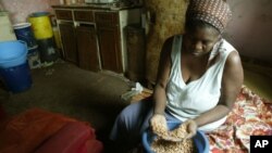 FILE: Faustine Janjira prepares food at her home in Highfields, a high density surburb in Harare, Tuesday, Oct, 17, 2006. Janjira who lives with her sisters who have 10 children in a 2 roomed house, struggles to feed the big family as only one member of the family works. Zimbabwe which marks International Poverty Reduction Day, faces a gloomy future in fighting poverty as it battles with the world's highest inflation currently running at over 1000 percent.(AP Photo/Tsvangirayi Mukwazhi)